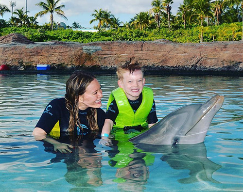 Hilary Duff Hialry Duff e Luca giocano con un delfino
